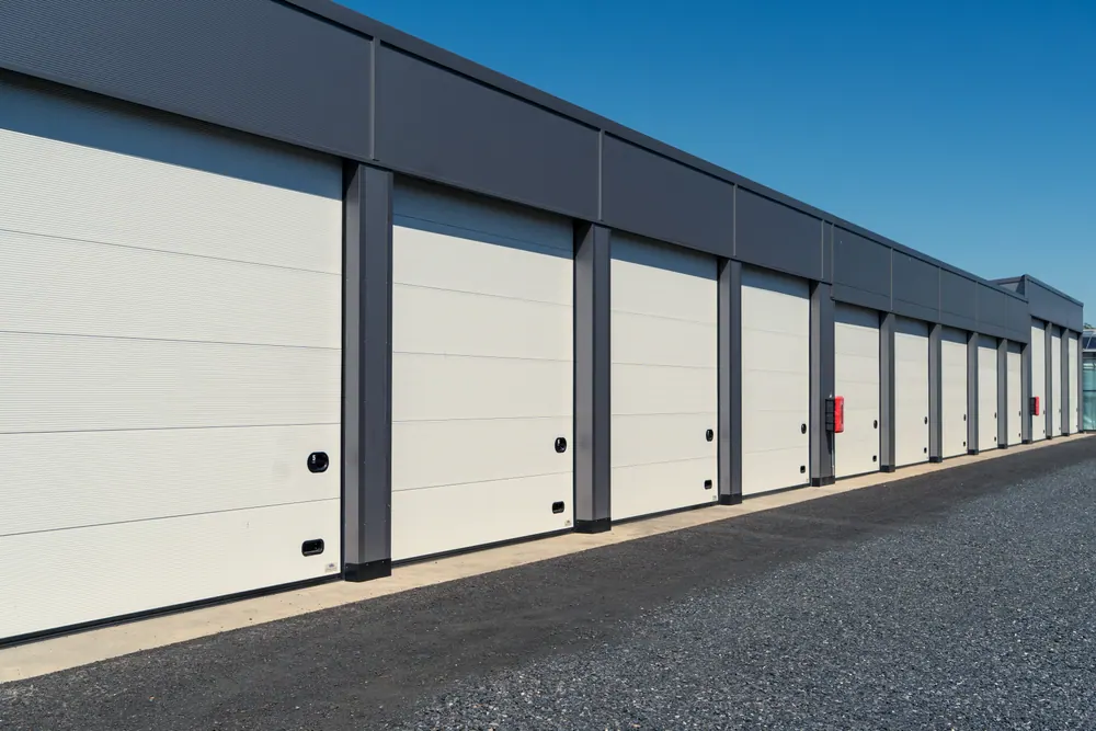 Garagenanlage mit weißen Sektionaltoren in der Perspektive