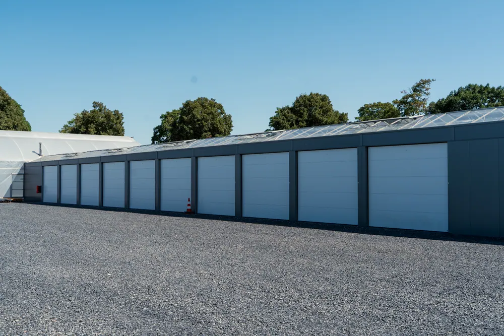 Lange Garagenzeile mit Sektionaltoren unter blauem Himmel