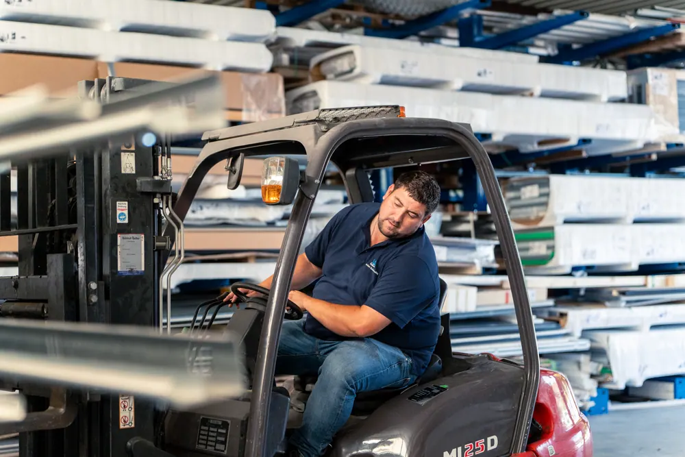 Mitarbeiter mit Gabelstapler im Materiallager