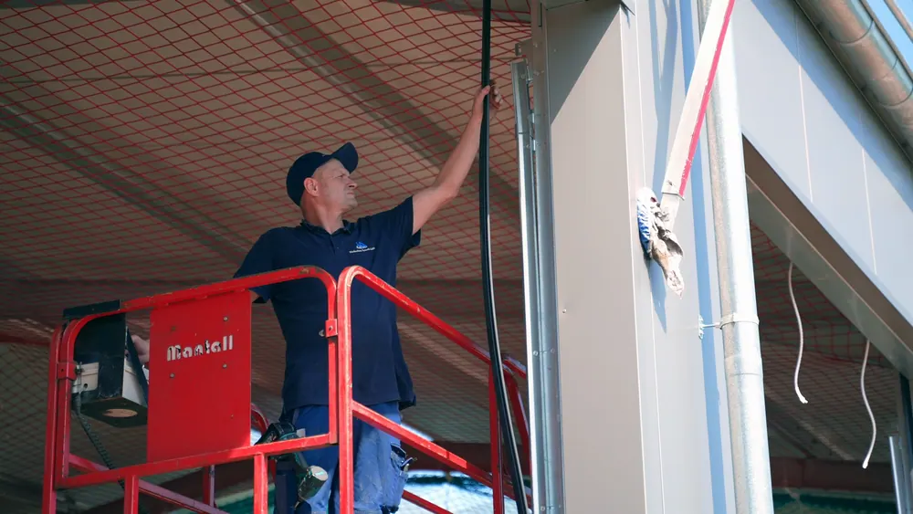 Monteur auf einer Hubarbeitsbühne bei der Montage eines Hallentors