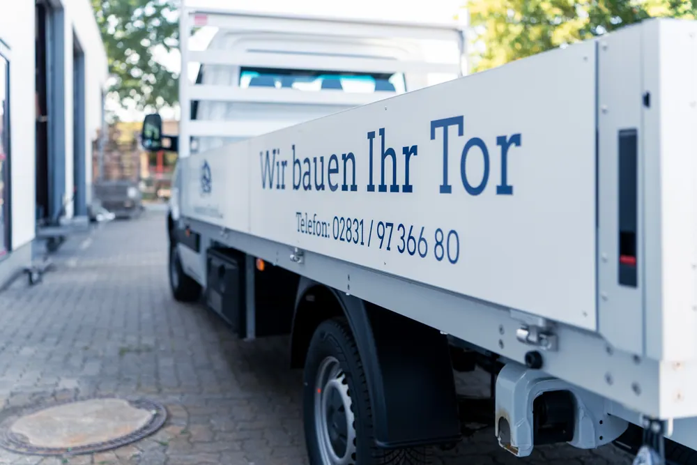 Pritschenwagen mit der Aufschrift „Wir bauen Ihr Tor“