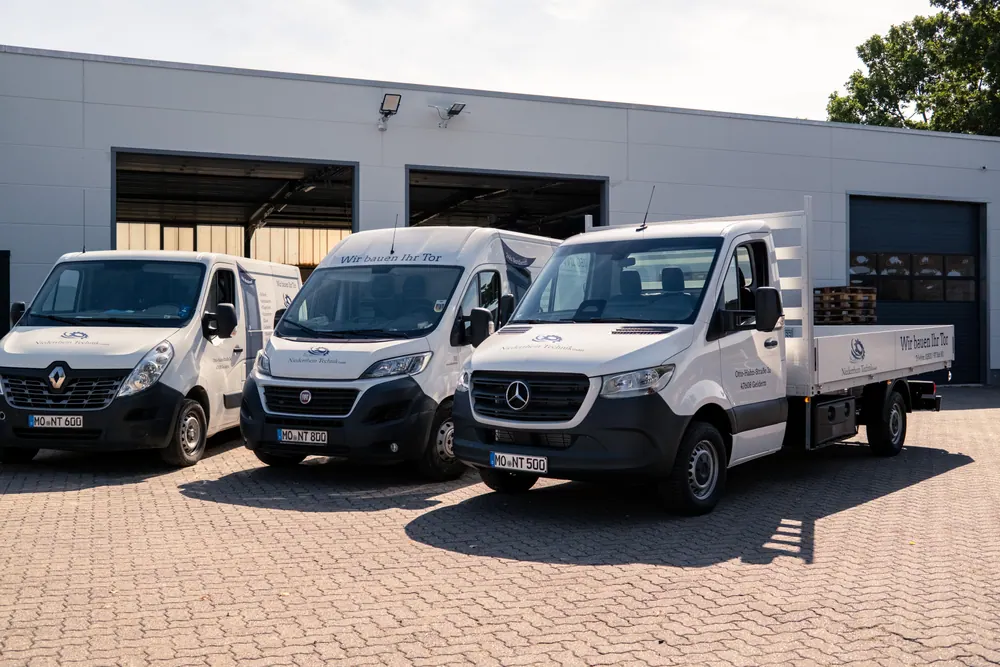 Transporter und Pritschenwagen vor der Firmenhalle